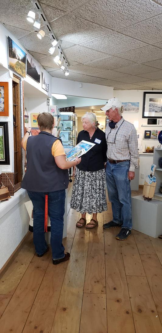 Celeste and Gary are visiting with a guest during the Monthly Artist Meet and Greet.