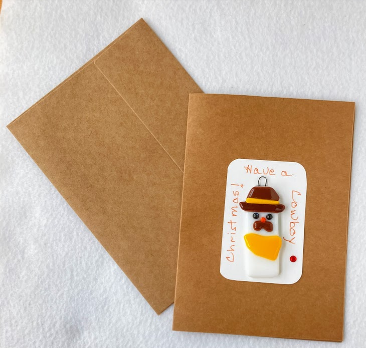 " Have a Cowboy Christmas 3 " Twinkle Eye Christmas Ornament And Card
Artist: Shari Wolf
Fused Glass Christmas Ornament
Snowman cowboy
Brown hat with gold stripe and yellow bandana
Large mustache
A small twinkle in the snowman's eye
Included is a 5" x 7" blank Kraft paper card with envelope
A perfect gift for the holidays