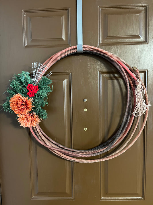 " Red Fall " Rope Wreath Artist: Aleah Russell  Repurposed lariat rope  Rope came from an authentic Wyoming ranch  Faux greenery, red roses, orange flower and pears all attached to a red rope  Will add a touch of country to any home  25" long x 24" high x 5" wide