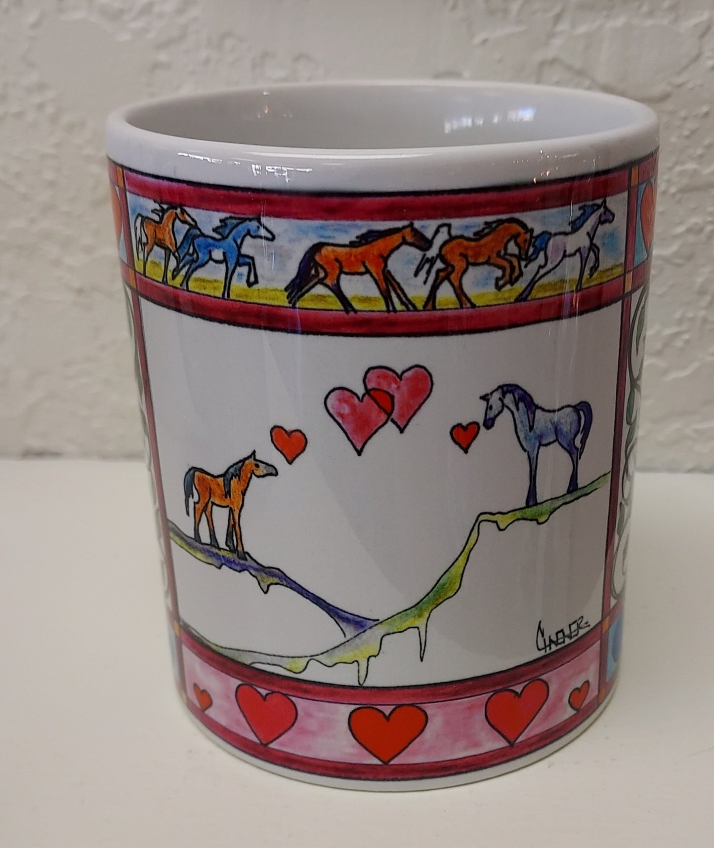 " Mustang Love " Mug Artist: Celeste Havener 8 oz white ceramic mug with handle Print of the original drawing " Mustang Love " is on the mug " Mustang Love " is an original drawing by the artist Great for a cup of coffee or tea