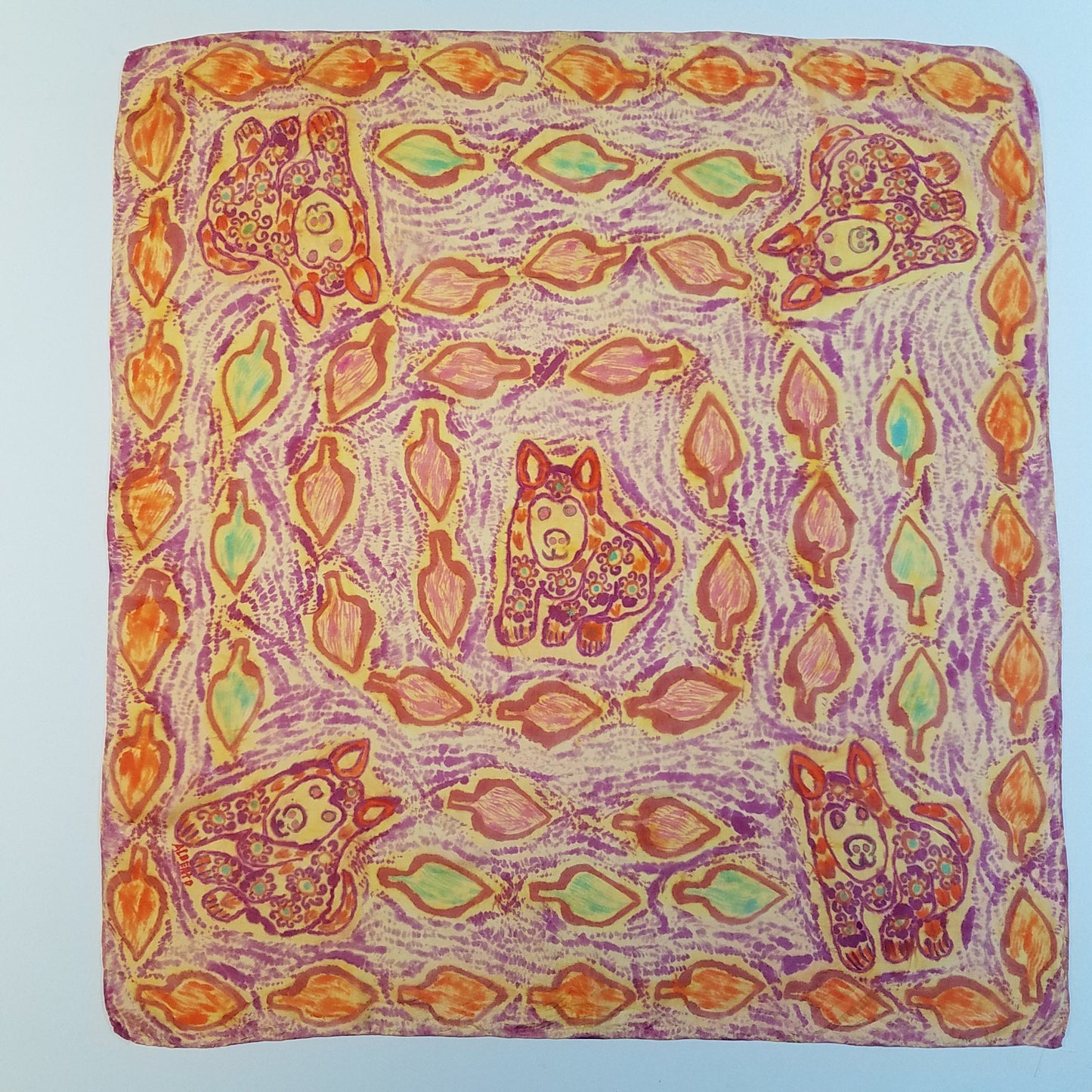 5 puppies painted in the Paruvian style. One in the center and one in each corner. Leaf pattern in spirals around the shawl