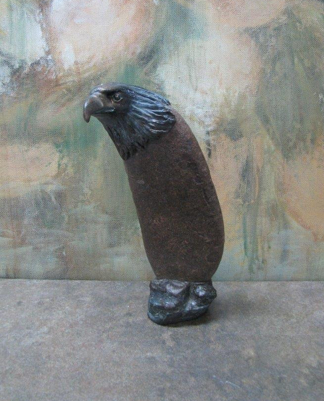 " Eagle " Stone And Bronze Sculpture Artist: Catherine Holt Wyoming found stone Cold cast Bronze eagle Sculpture measures 2.25" x long 7" high x 2.25" wide Stone appears to have been a tool used by natives Bronze base