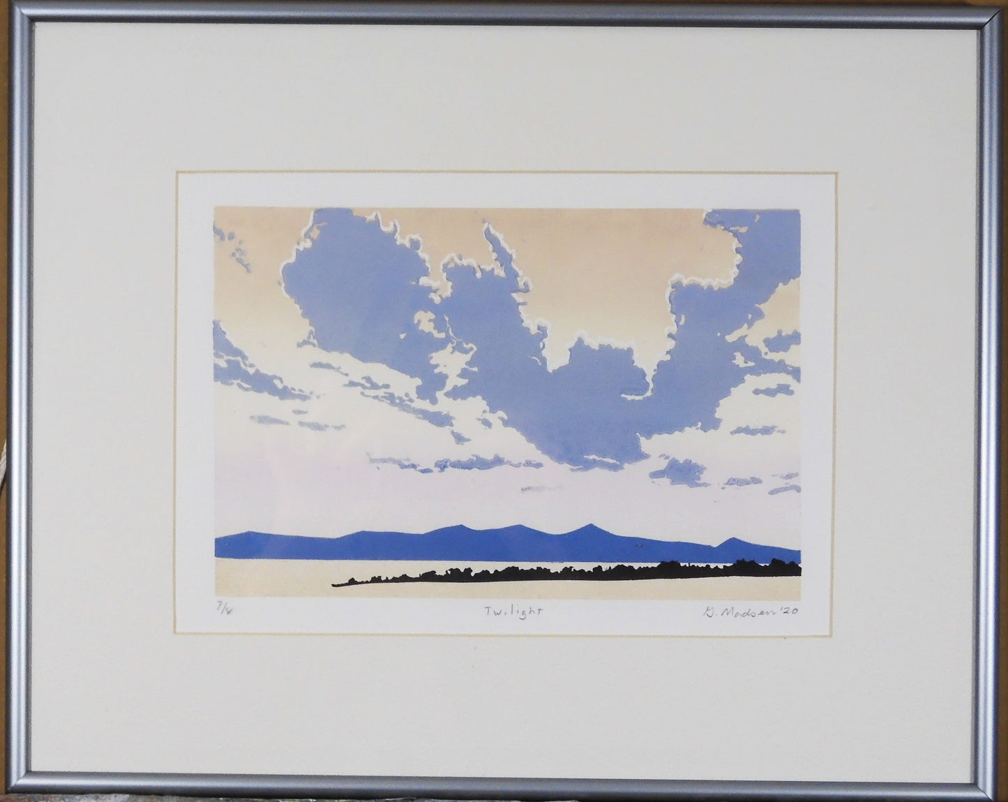 "Twilight" Framed Relief Print Artist: Ginnie Madsen Framed White Mat Narrow silver frame Big gray clouds against the distant blue mountains 6" wide x 9" long x 1" deep print only 12" wide x 15" long x 1" deep framed only Relief print Please note, each relief is custom designed by the Artist , with a slight variation between each relief print