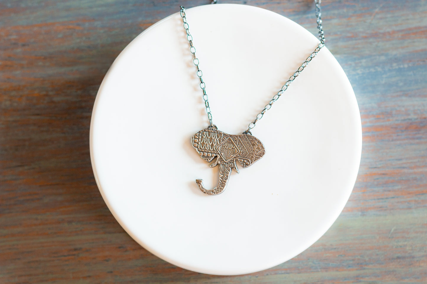 Large Elephant Head Necklace Jewelry Artist: Kristie Brown Large Elephant Head pendant Stamped Sterling Silver Elephant Head 16" Sterling silver chain 1 1/2" long x 1 1/2" wide pendant Please note, each piece is custom designed by the Artist , with a slight variation between each piece