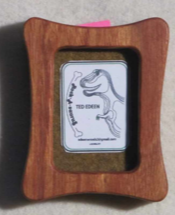 Rectangular frame with rectangle opening  Canary Wood  Beautifully handcrafted wooden frame  2 1/4" long x 3" high x 3/4" wide  Will sit on a shelf or a small easel (not included)  Four movable tabs allow access to change out photographs