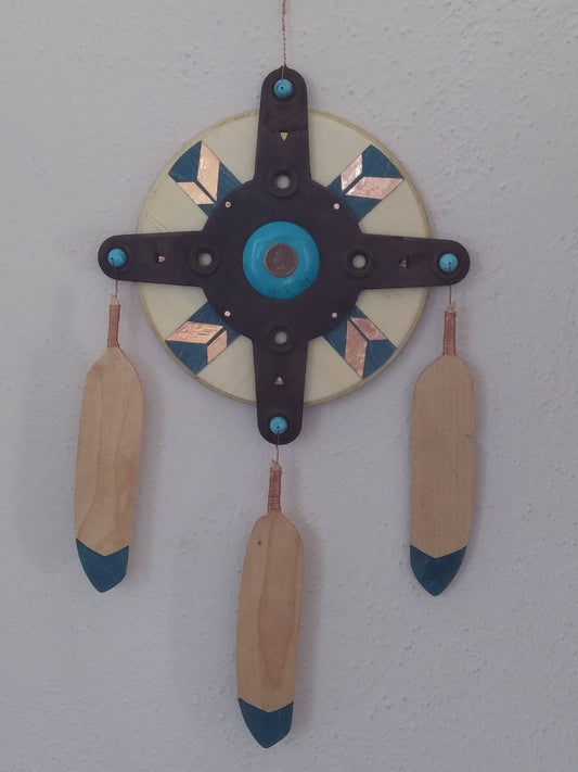 Round board with metal spokes, Indian head penny in center  Round back board stained blue with copper off sets  Three wooden feathers with blue tips hang from metal portion of mandala  Southwest style Mandala