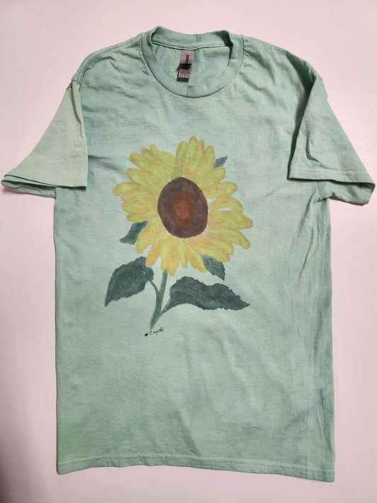 Adult Small " Sunflower " Tee Shirt Artist: Crystal Lawrence Hand painted and dyed  Size Adult Small  Hand painted yellow sunflower on a hand dyed green t-shirt  Hand signed by the artist herself  100% Cotton  Hand Wash  Artwork that you can wear  Please note, each piece is a handmade custom designed by the Artist , with a slight variation between each piece