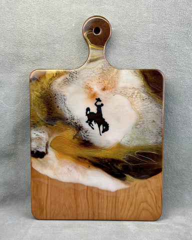 brown, yellow, white resin on a cherry wood board with a bucking horse and rider decal. 24K gold accent