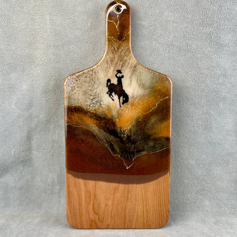 rusty brown and cream colored resin with 24K Gold accent and a bronc rider on a cherry wood boad