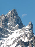 " Day Moon " Photograph Artist: Ashleigh Monaco  The Grand Teton / Teewinot up close  Snow is lingering on the rugged mountains while the moon peaks out during the day. Lustre print in protective sleeve.