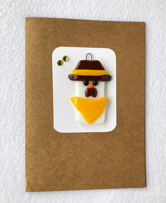 Fused Glass Christmas Ornament  Snowman cowboy with brown hat with gold stripe  Yellow Scarf  2' wide 2' long 0.25 high ornament  Included is a 5" x 7" blank Kraft paper card with envelope  A perfect gift for the holidays or for any pokes fan