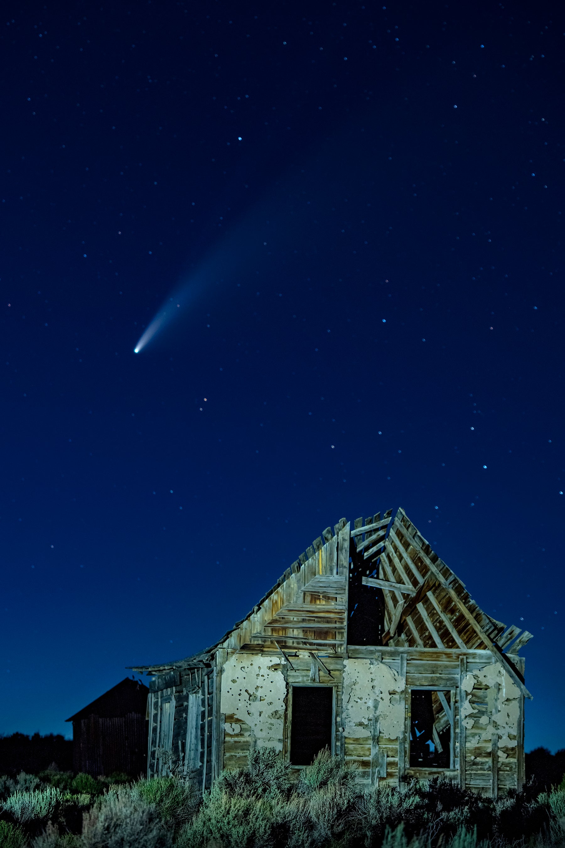 Comet Neowise fills the night sky over the Oregon Trail era ruins in the Piedmont area east of Evanston Wyoming