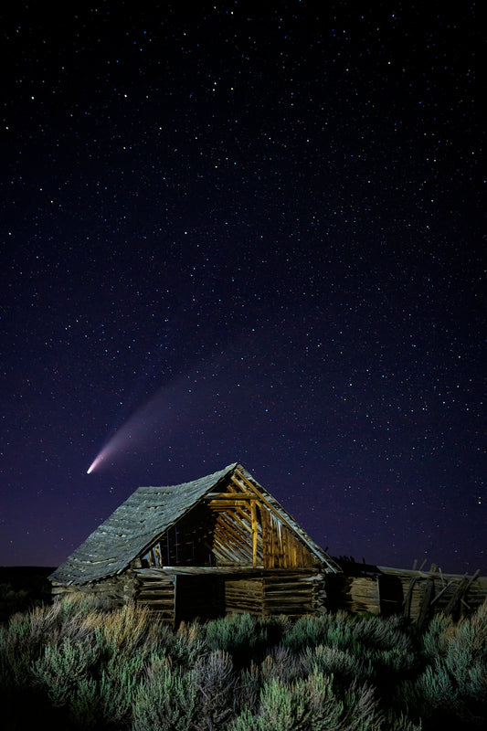 Nighttime exposure of an old barn ruins in the ghost town  Comet Neowise fills the night sky over the Oregon Trail era ruins in the Piedmont area east of Evanston Wyoming