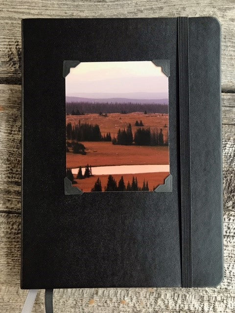 Libby Flats Lined Black Leather Journal Artist: Lisa Edwards - Photographer  Black Leather Cover  Photograph of Libby Flats in the Snowy Range mountains west of Laramie Wyoming  8" long x 6" wide x 3/4" deep  Black elastic strap for holding book securely closed  Please note, each piece is custom designed by the Artist , with a slight variation between each piece