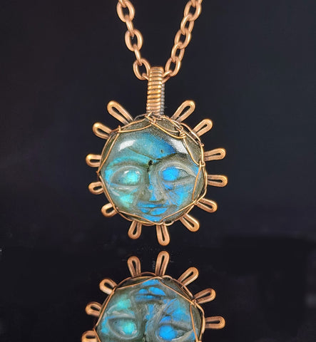 Carved sun face in labradorite wrapped in oxidized copper wire to look like the sun  1.26" Long x 1" Wide  Copper chain with lobster clasp closure  A truly one-of-a-kind piece of jewelry  Care instructions with polishing cloth included  Unique piece to brighten someone's day
