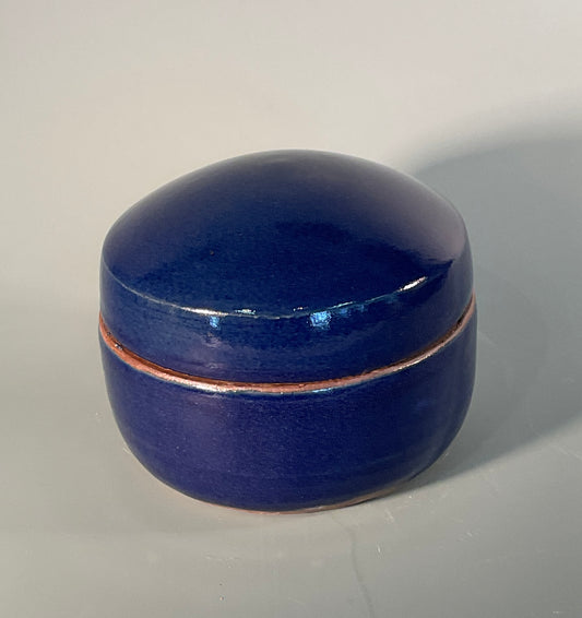 Hand thrown round box with lid  Outside is blue glaze  Inside of box is chun glaze