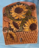 Ladies clutch wallet  Hand tooled Sunflowers with basket weave stamping decorate the leather  Sunflowers are dyed to allow them to shine  Stainless steel clasp to hold wallet contents securely  Hand stitched  Teal interior  Paper money pocket  Zippered coin pocket  Checkbook holder  12 Card slots  7" long x 3 1/2" high x 1 1/2" wide