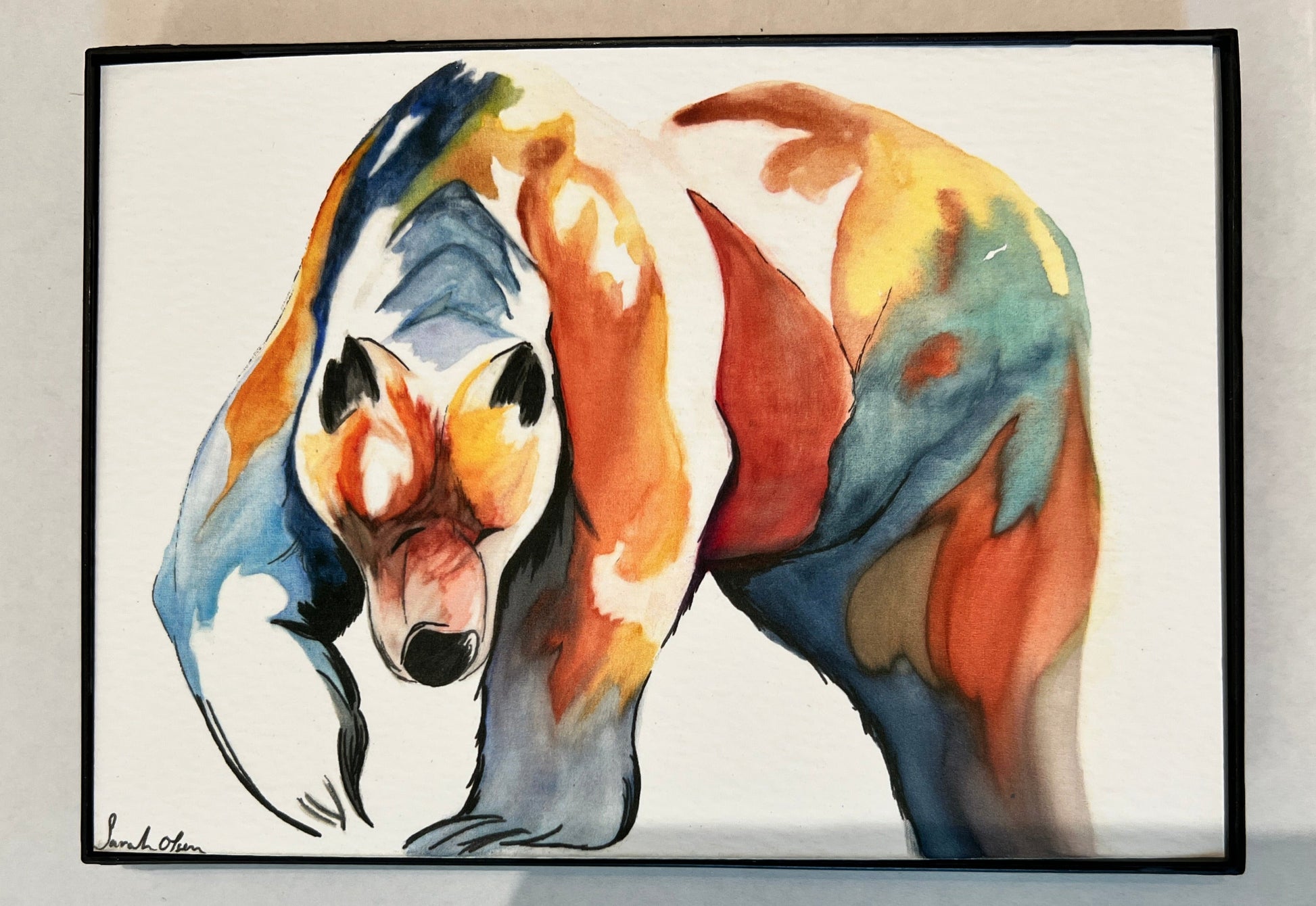 " Bearly There " Framed Watercolor Print Artist: Sarah Olsen Print from an Original Watercolor Painting  Bear walking with right paw up off the ground  Multicolored bear  Natural with an abstract look  Choose From:  Print  Framed 5" long x 7" high print  Printed on watercolor paper  In a slim black plastic frame