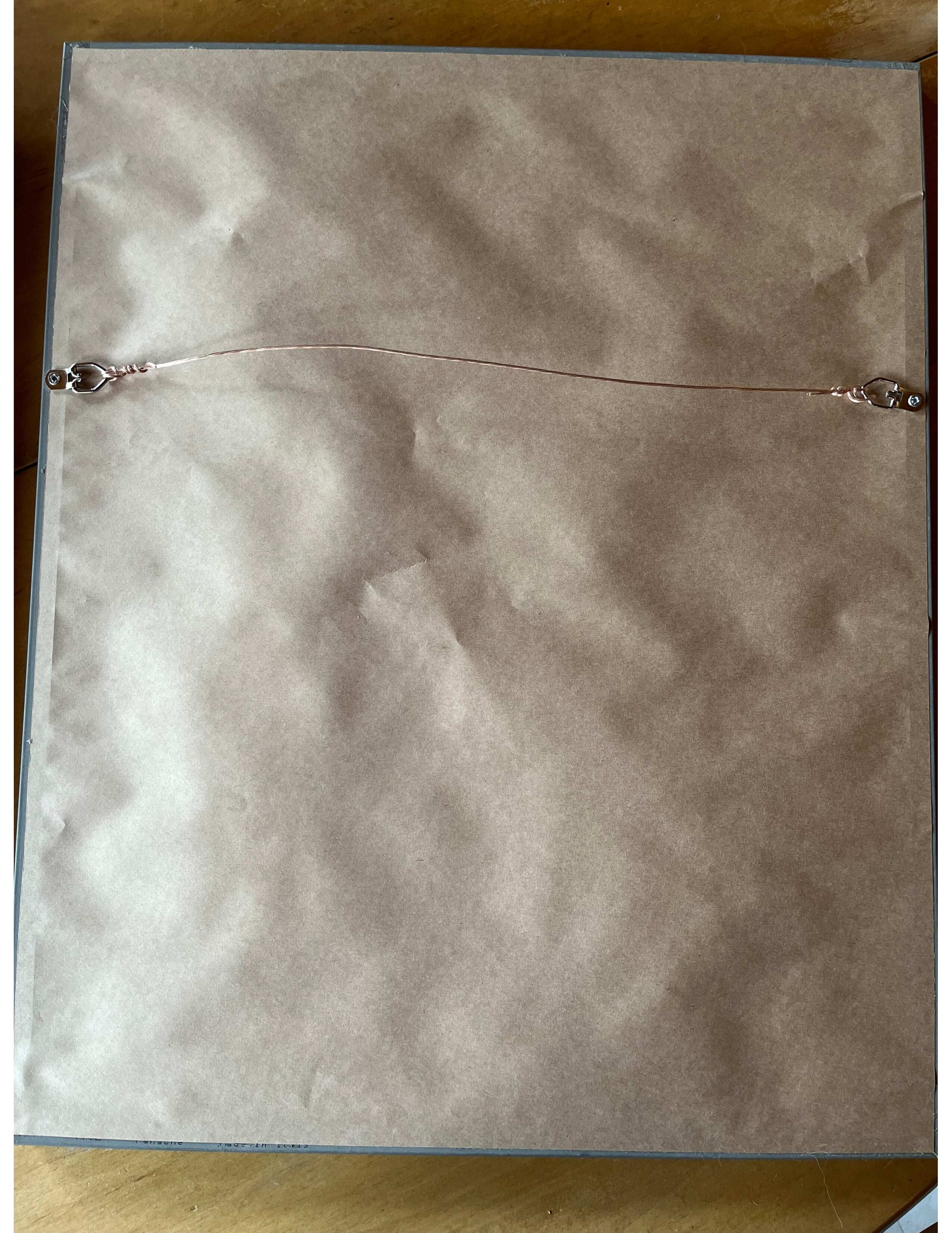 back of the artwork shows d-ring with wire for hanging