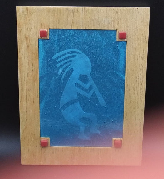 stained and etched glass in a wooden frame. etching is of KoKoPelli