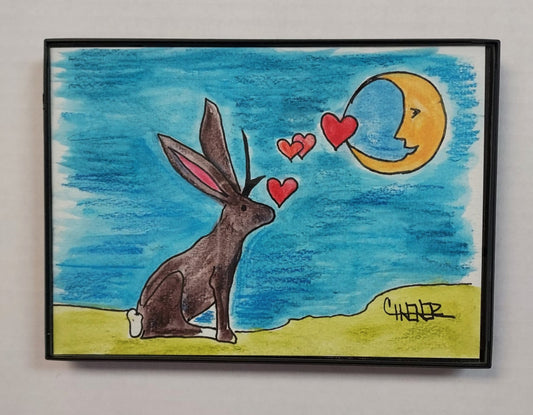 Jackalope Loves Moon " Framed Original Watercolor and Ink Artist: Celeste Havener Original watercolor and ink drawing  Jackalope looking up and sending hearts to the moon  Teal blue sky with green ground hill in the background  Framed in sleek black plastic frame  Can be hung on a wall or use the frames easel back to set on a table  Would make a great wedding or anniversary gift  7" long x 5" high x 1/2" deep  Please note items are originals a