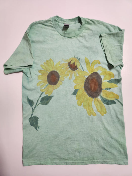 Adult Medium " Sunflower " Tee Shirt Artist: Crystal Lawrence Hand painted and dyed  Size Adult Medium  Hand painted with 3 yellow sunflowers on a hand dyed green t-shirt  Hand signed by the artist herself  100% Cotton  Hand Wash  Artwork that you can wear  Please note, each piece is a handmade custom designed by the Artist , with a slight variation between each piece