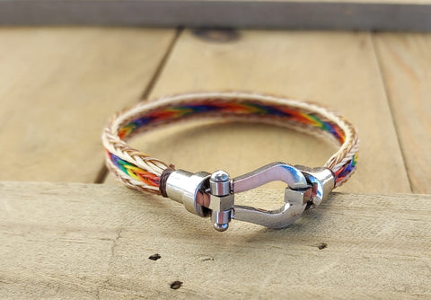 Hand braided horsehair  Brown and white border with rainbow center ( natural and dyed horsehair )  Hinged stainless steel magnet clasp  3/8" wide  8" wrist