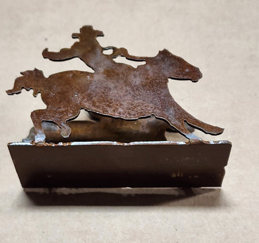 " Cowboy " Metal Card Holder Artist: Michael McMahon Metal cutout of a Cowboy riding a horse  Rustic Patina finish  Cowboy is bent up from the base to hold business cards or as a small napkin holder  Clear coat enamel finish  3.5" long x 2.5" high x 1.5" wide