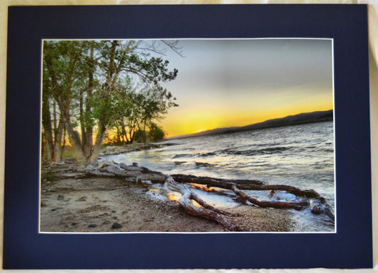 Matted color photograph of Boysen State Park in Fremont County Wyoming  A lake-oriented park at the south end of the Owl Creek Mountains in the mouth of the Wind River Canyon  Sunset on the lake would be a great place to relax and unwind  Matted in a navy blue matting  18" long x 12" high print  22" long x 16" high as matted  In a plastic sleeve and on sturdy foam board for added protection  Ready for a frame or to be displayed on an easel