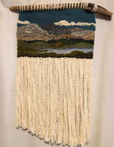 Hand woven tapestry made from recylced and thifted material.  Zero waste. Depicts the wind River mountains of Wyoming. Hangs from a piece of drift wood.
