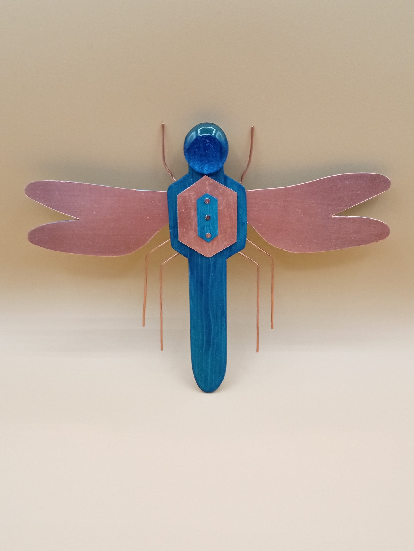 Blue wood body  Hand cut copper sheet makes up the wings  Copper wire legs  Blue Glass Stone head .  Blue wood body  Hand cut copper sheet makes up the wings  Copper wire legs  Blue Glass Stone head  9.5" long x  8" wide x  1" high  Wonderful year around decoration  Great for any insect enthusiast