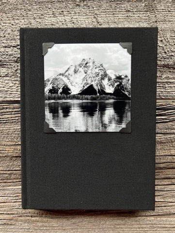 Hardcover black sketchbook  Black and White photograph of Mt. Moran of the Grand Tetons in Wyoming is attached to the cover of the sketchbook  Elastic pencil loop with pencil included  Blank pages for sketching  Take with you anywhere you go  6" long x 8" high x 3/4" wide