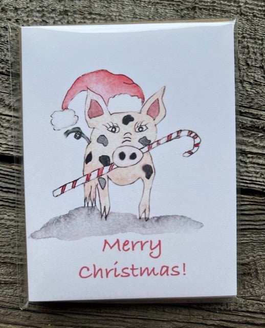 " Merry Christmas " Pig with Candy Cane Greeting Card Pack Photographer: Lisa Edwards From and original watercolor painting by the artist  Little spotted pig holding a candy cane in its mouth and wearing a Santa hat  4 blank cards with Kraft envelopes included  4 1/4"long  X 5 1/2" wide  Fun card to send out for Christmas wishes