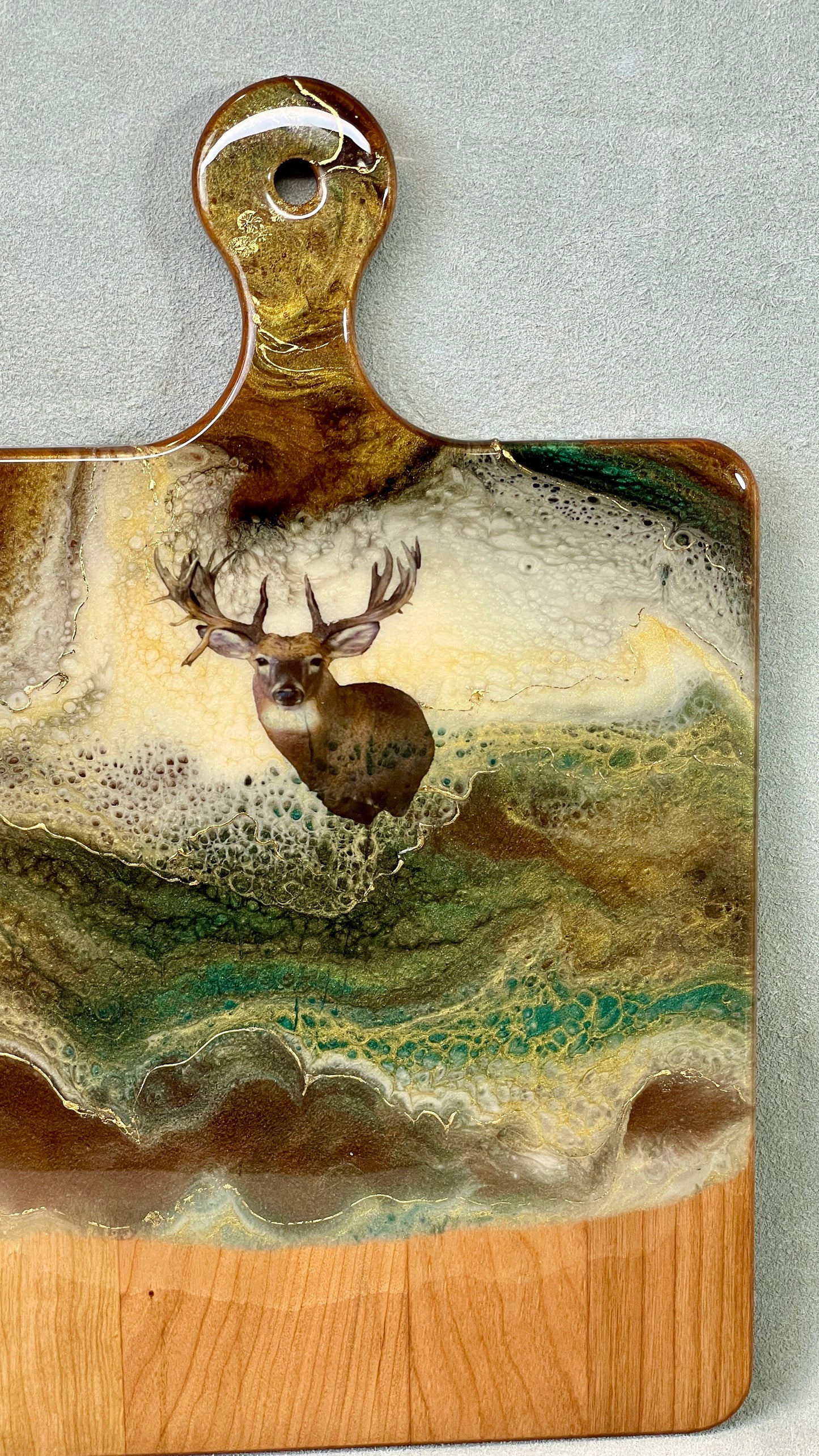 Handmade, sanded, and conditioned for functionality and longevity, this serving board was accented with original resin artwork and an decal of the large rack muledeer, by the artist herself, making it a true one-of-a-kind original piece that will showcase in your home beautifully. 