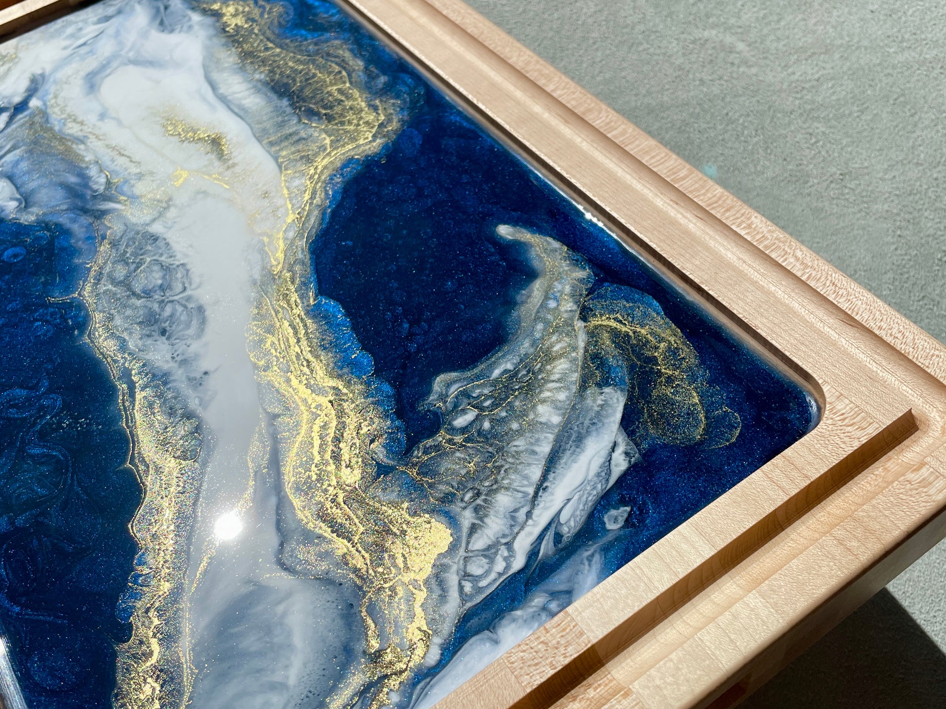 Impressive Artisan Resin / Wood Charcuterie Cheese Platter / Juice Artist: Marcy Knotwell Blue, white with liquid gold lacing resin designs  Made from stunning maple wood, the natural hardness and unique resin color sets this charcuterie cheese board apart from any other. The artistic tone and delicate highlights brings this original piece of art front and center as a stylish, multi-functional, sustainable serving piece.