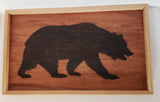 Cedar wood frame around a wood burned silhouette of a walking bear.