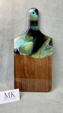 Product Features: • Handmade, High Quality, an Original • Solid Walnut Hardwood • Dimensions: 17" L X 8" W X .75" H • Artistically Crafted • Original Resin Artwork by the artist herself • Treated with an organic house-made wood conditioner  Greens of varying hues with black and a hint of irridescent blue accents