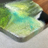 Handmade, sanded, and conditioned for functionality and longevity, this serving board was accented with original resin artwork by the artist herself, making it a true one-of-a-kind original piece that will showcase in your home beautifully.  Our wood and resin serving boards offer an easy, unique entertaining solution that is ready to impress from big crowds to intimate gatherings for years to come setting the perfect stage for entertaining or gourmet gifts.