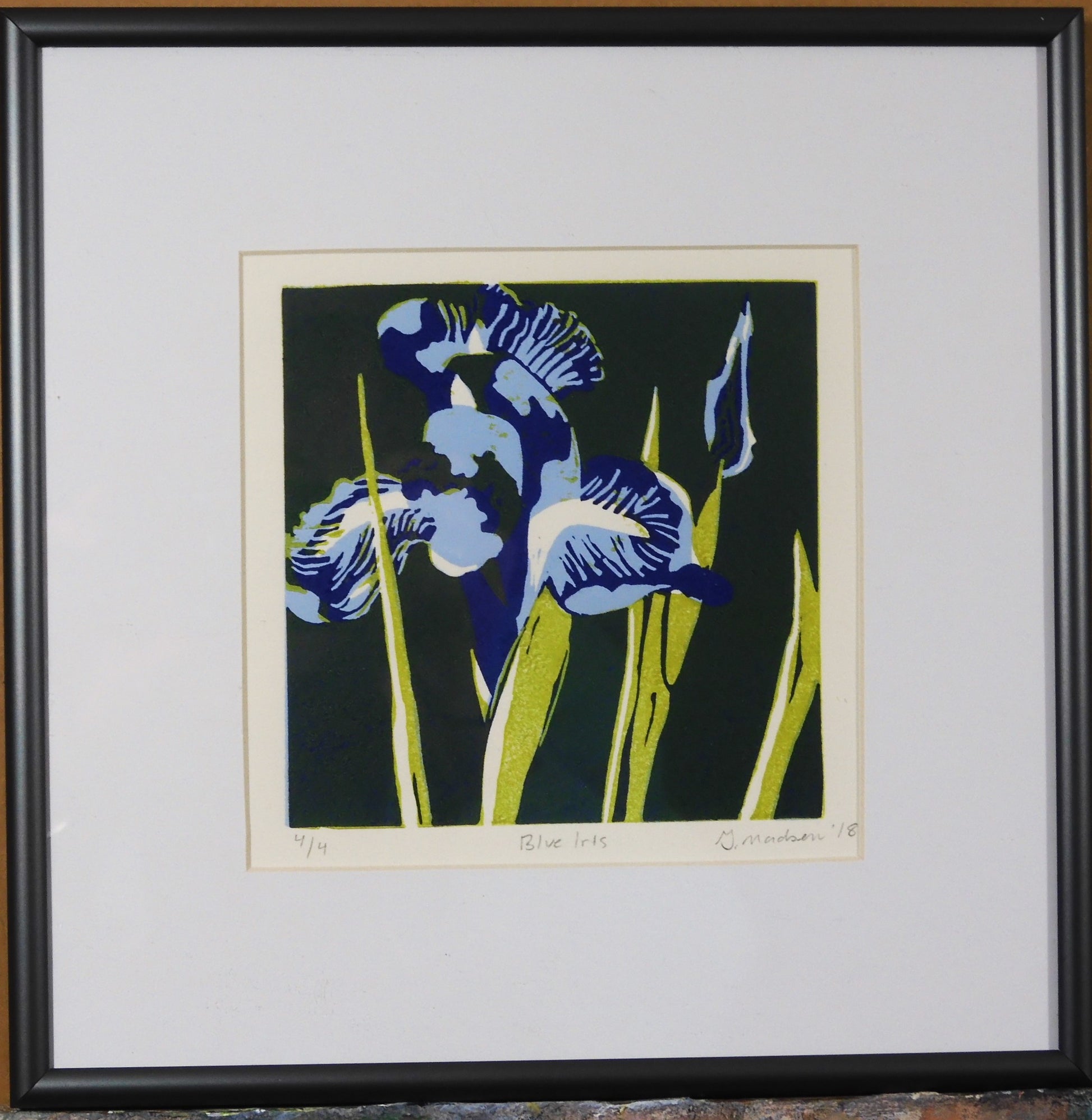 " Blue Iris " Framed Original Relief Print Artist: Ginnie Madsen  Blue Iris on a dark green background  2" white matting around the relief print  5" long x 5" high print only  10" long  x 10" high x 1" inside a dark silver metal frame  Wire attached to frame for hanging  Original Relief print  # 4 of 4  Ready to brighten up any room in your home