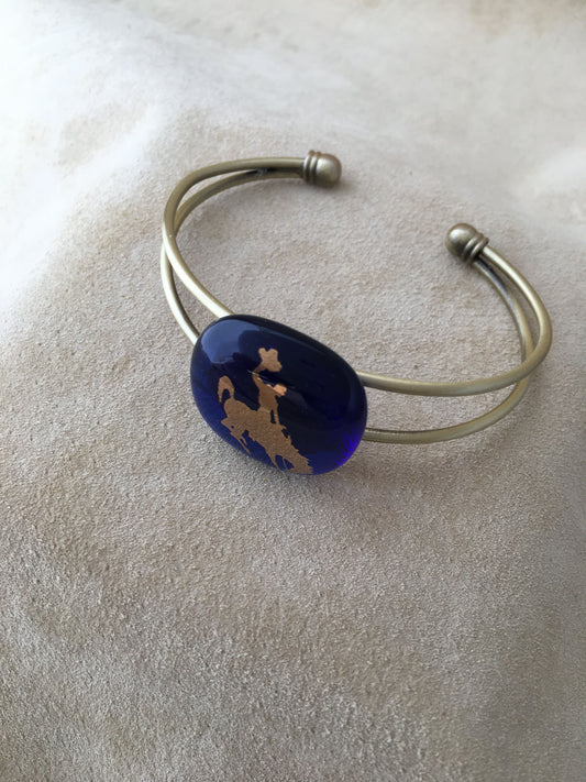 Adjustable bracelet with a blue fused gall focal piece with 22kt gold university of Wyoming Bucking bronco and rider