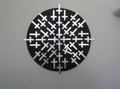 "Cross Roads" Mandalas w / Cross Mixed Media Artist: Bruce Allemani Round black board with aluminum crosses   Brass screws hold crosses on round black board  Wire on back for wall hanging  12" long x 12" wide x 1/2" high  Please note, each piece is custom designed by the Artist , with a slight variation between each piece