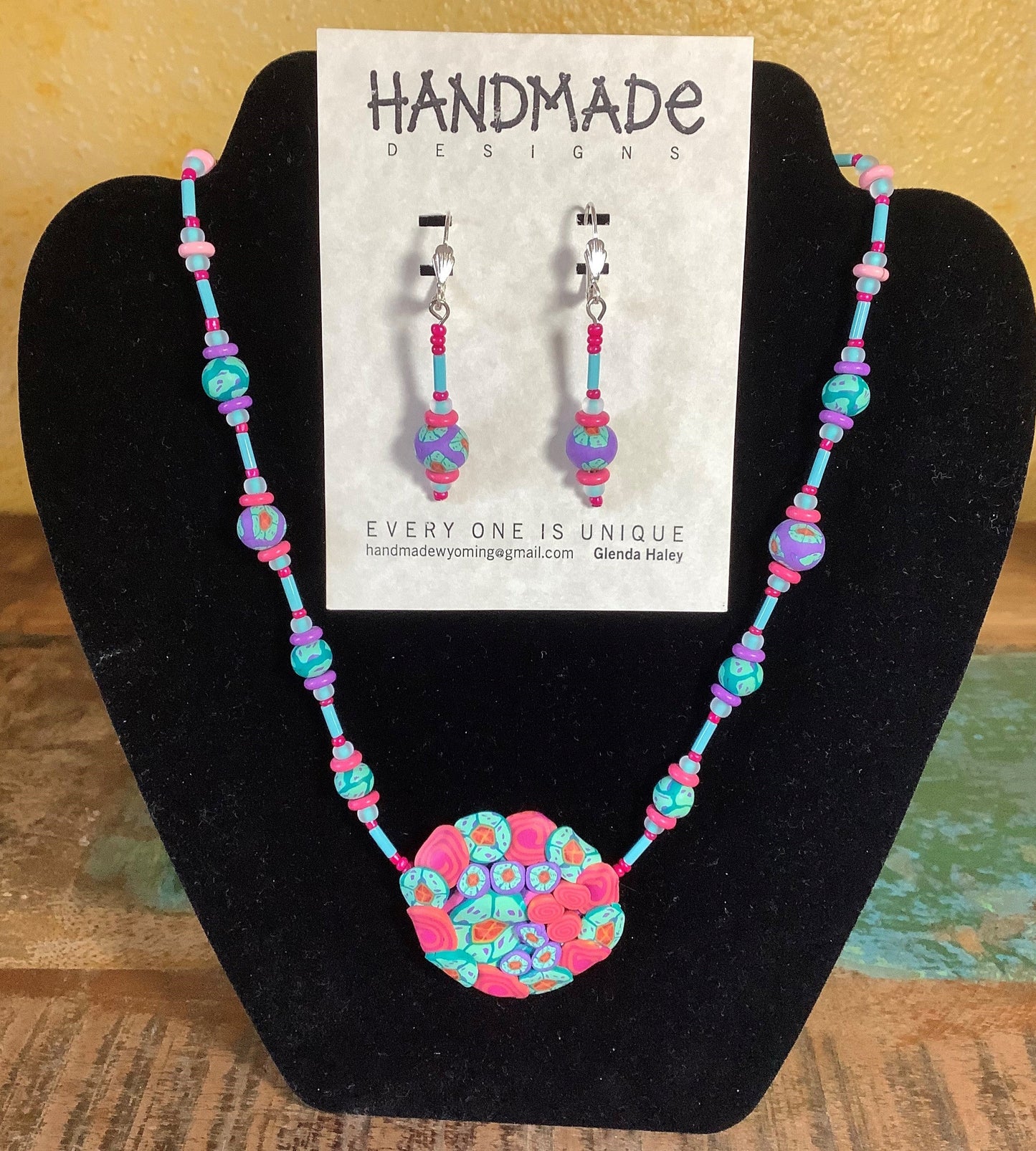 Teal and Pink swirl beads. Necklace: Variety Mixed Colors Polymer Clay Necklace and Earring Set Artist: Glenda Haley  Original, handcrafted Necklaces with matching Earrings  Created from Polymer Clay in Yellow, Orange and Purple swirls  The Earrings are drop beads from matching clay  Polymer Can Techniques  Beads are hand made  Glass accent be
