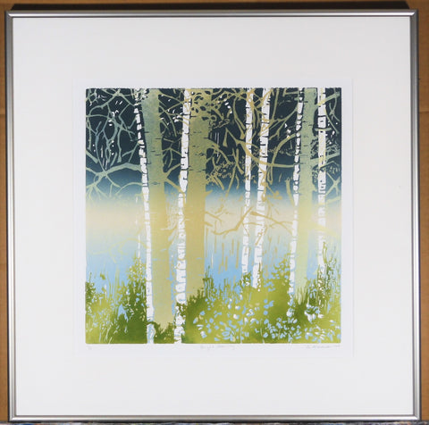 " Bright Morning " Original Relief Print.  Artist: Ginnie Madsen  12" x 12" print  19" x 19" Framed in a sleek silver frame.  From the artist:  I carve my design into the block’s surface, one block for each color.  The block is inked and each color is printed separately to develop the complete image  Imagery, as here in “Bright Morning”, usually develops from my observation of the county around the West  This print suggests a misty lake shore viewed through an aspen grove