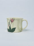 Hand thrown porcelain straight walled mug with handle  Pink Shooting Star motif is hand painted on the side of the mug  A green wash gives added color to the porcelain  Glazed porcelain allows for everyday use  4" long x 4" wide x 3" high  It is suggested to hand wash the mug