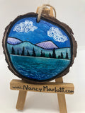 Representation of Lake Owen in the Snowy Range Mountains of Wyoming  Lake, mountains, and pine trees with a couple of puffy clouds in the sky