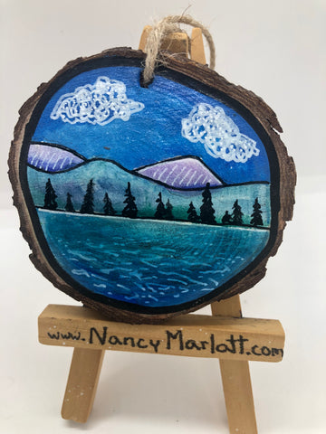 Representation of Lake Owen in the Snowy Range Mountains of Wyoming  Lake, mountains, and pine trees with a couple of puffy clouds in the sky