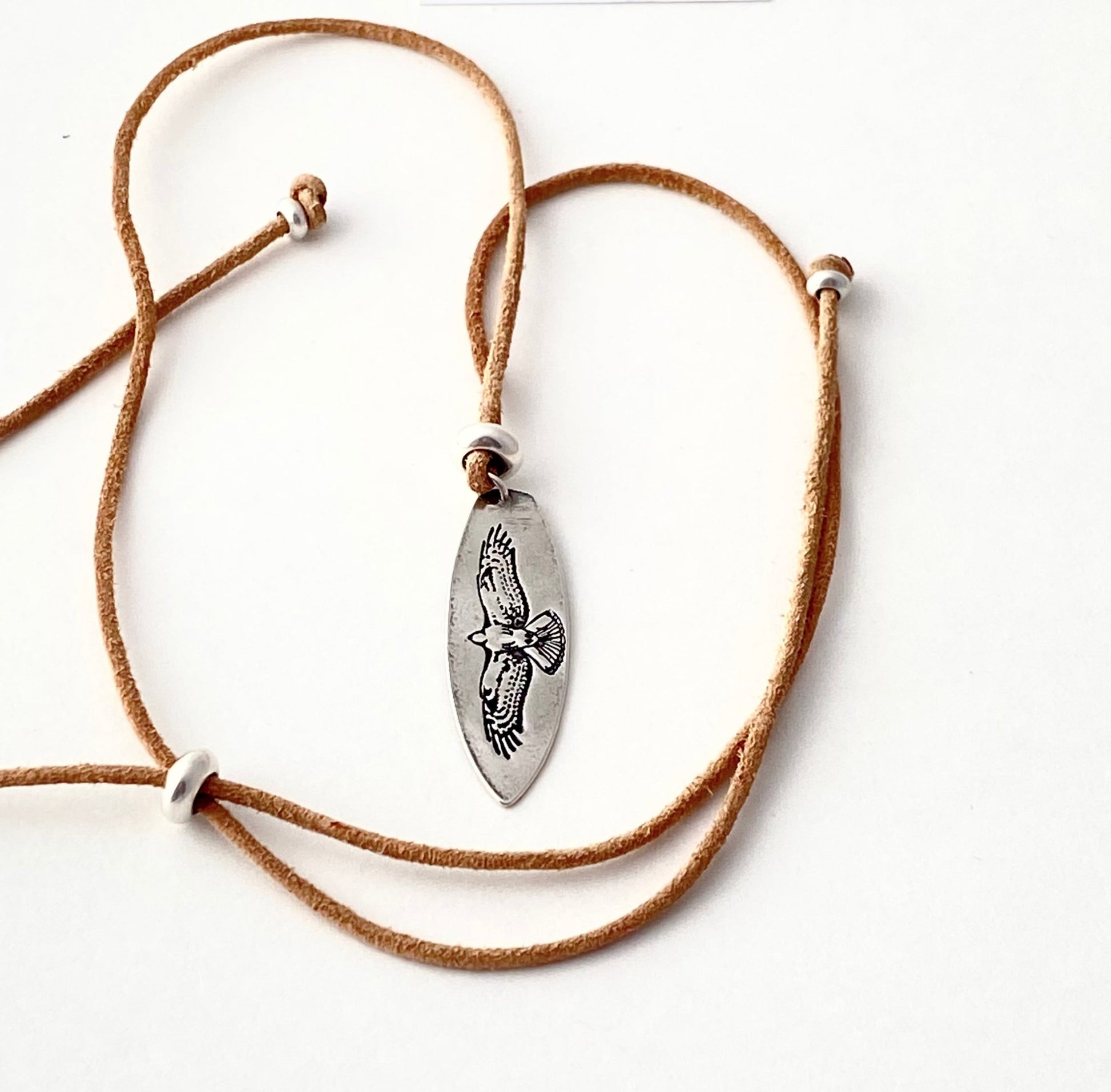fine silver pendant with soaring hawk design. surf board shape pendant. leather adjustable cord
