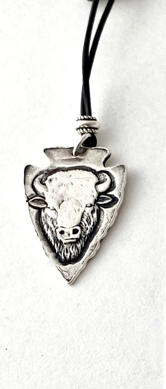 Fine Silver Buffalo Head Pendant Jewelry Artist: Kristie Brown Fine Silver Arrowhead pendant with Buffalo Head  1" long x 3/4" wide  Black leather adjustable cord necklace 20" long