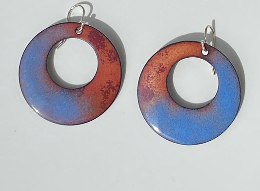 Hoop Half And Half Enamel Earrings Jewelry Artist: Kristie Brown Half Blue and Half Brown pattern enamel earrings  Round Hoop shaped Earrings  1 1/4" long x  1 1/4" wide  Sterling Silver ear wires  Please note, each piece is custom designed by the Artist , with a slight variation between each piece