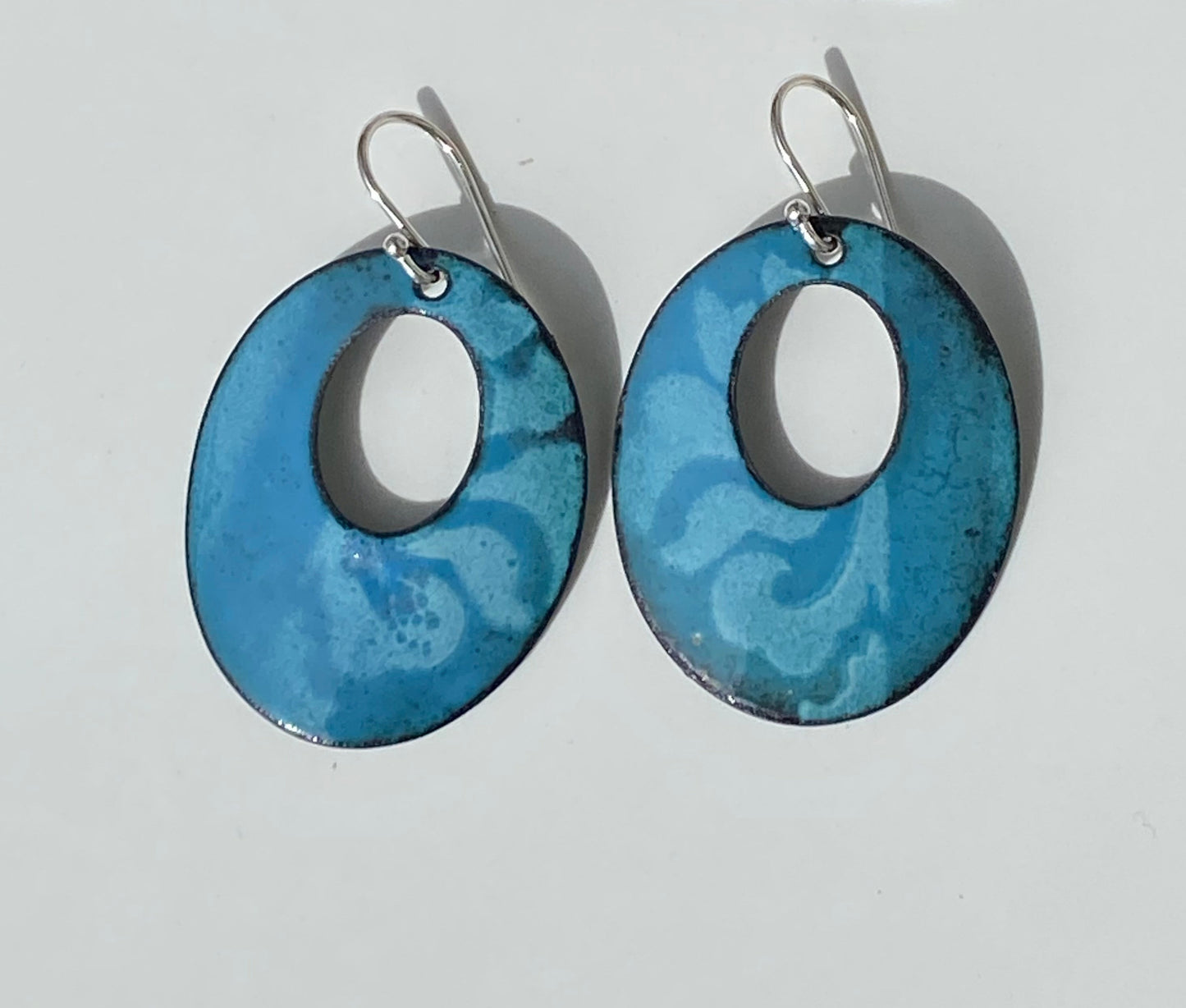 Oval Hoop Filigree Enamel Earrings Jewelry Artist: Kristie Brown Bluish Green color with filigree pattern enamel earrings  Oval Hoop shaped Earrings  1 1/2" long x  1" wide  Sterling Silver ear wires  Please note, each piece is custom designed by the Artist , with a slight variation between each piece